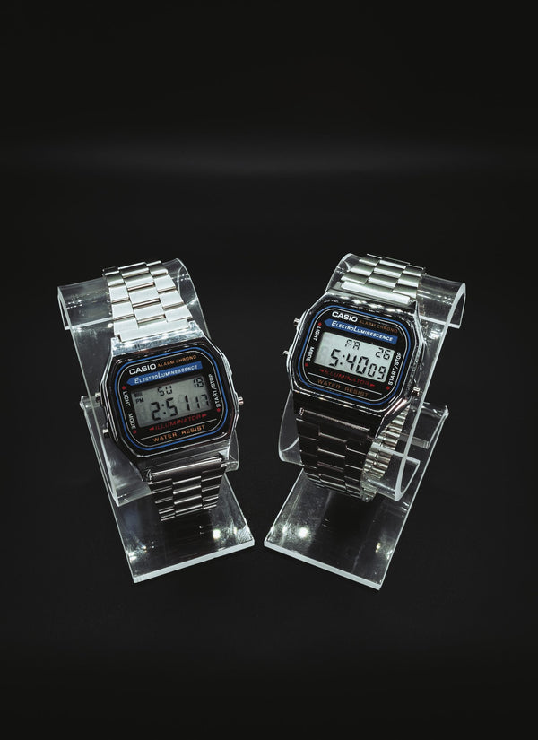 Two Casio A168 digital watches on clear stands