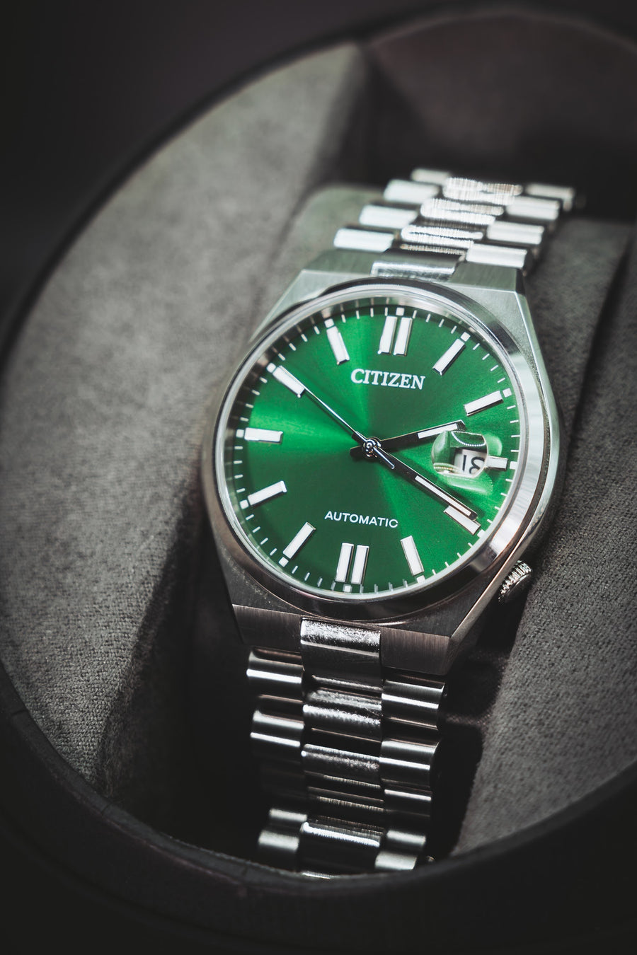 Citizen Automatic with a green sunburst dial, resting in its cushion