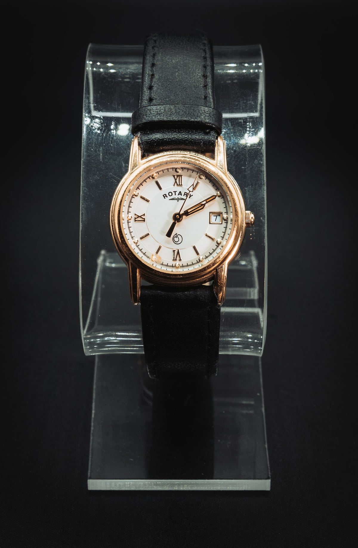 Gold-tone Rotary on a clear display stand