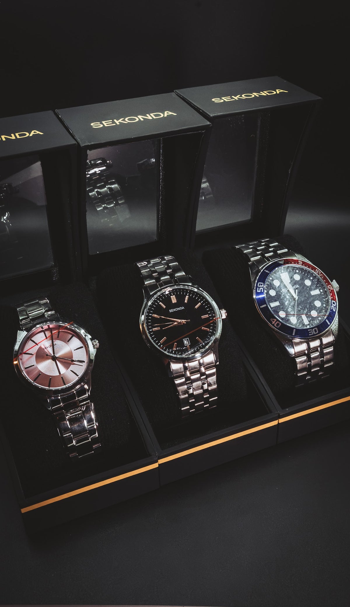 Three Sekonda watches side by side in their boxes